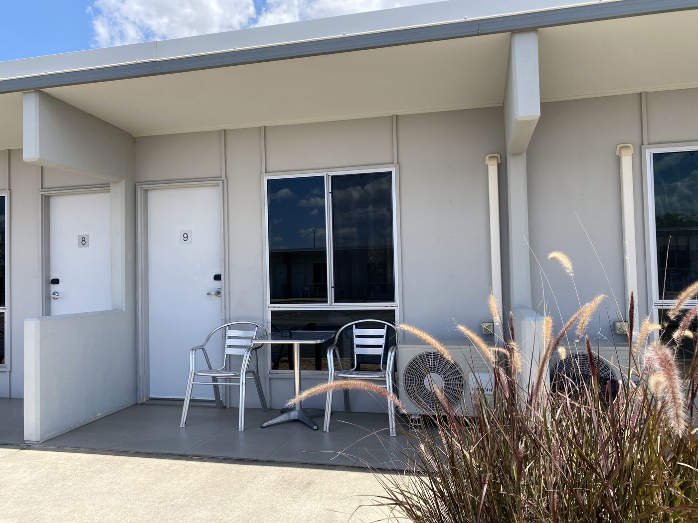 Room doors opening onto a shaded verandah with seating