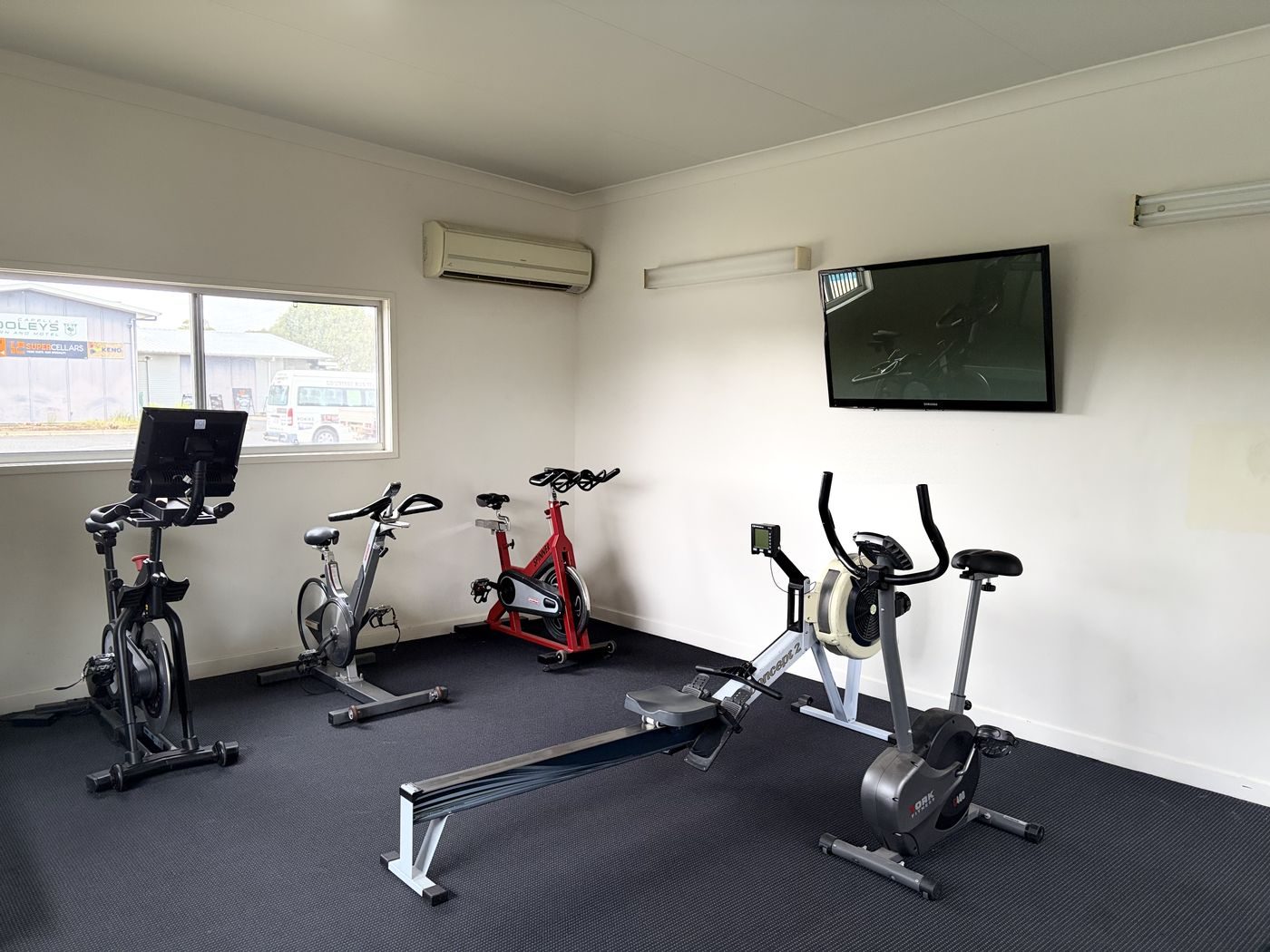 The 24/7 gym with a rower, exercise bikes and a wall-mounted TV