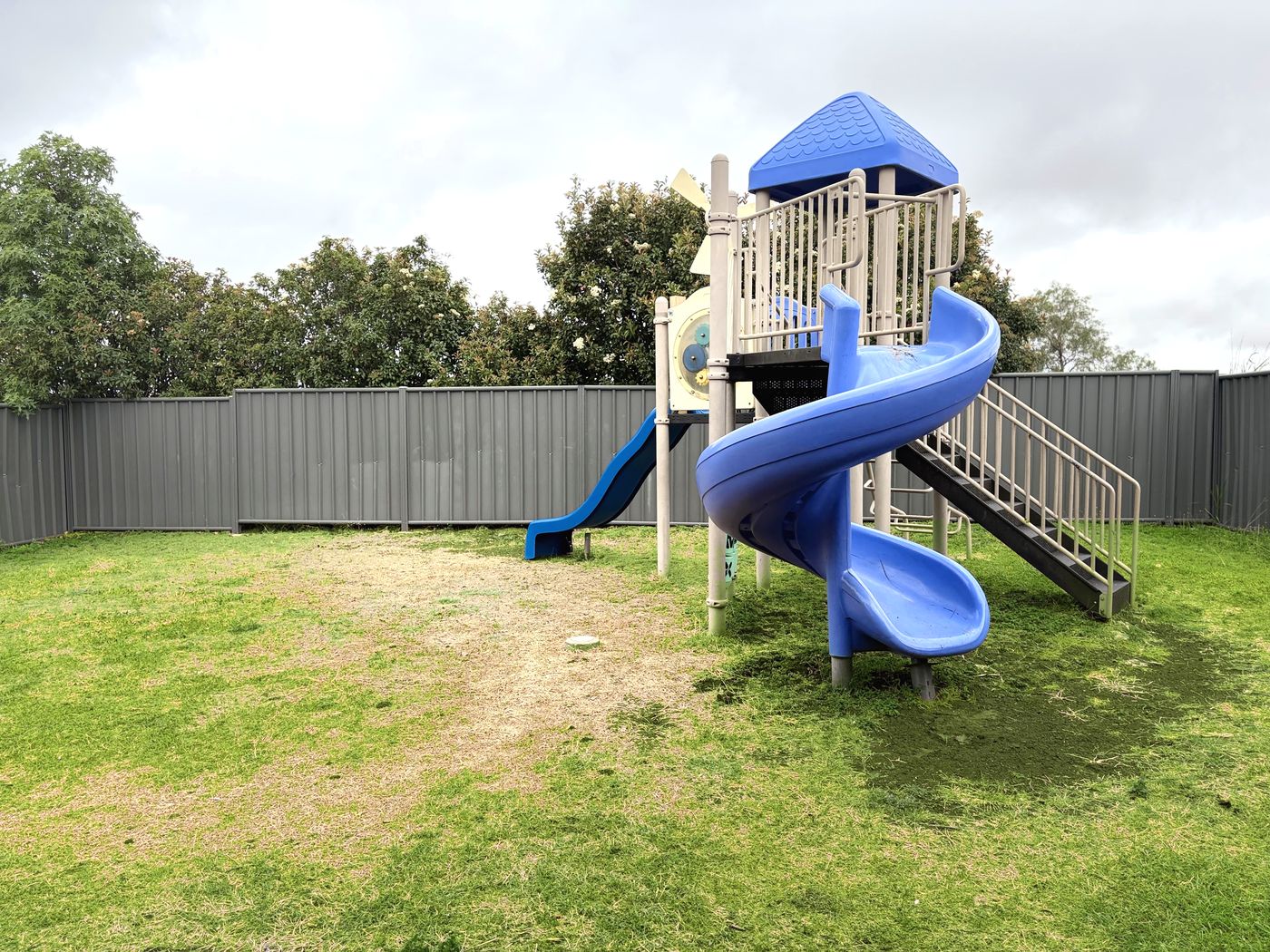 Kids' playground with a spiral slide on green grass