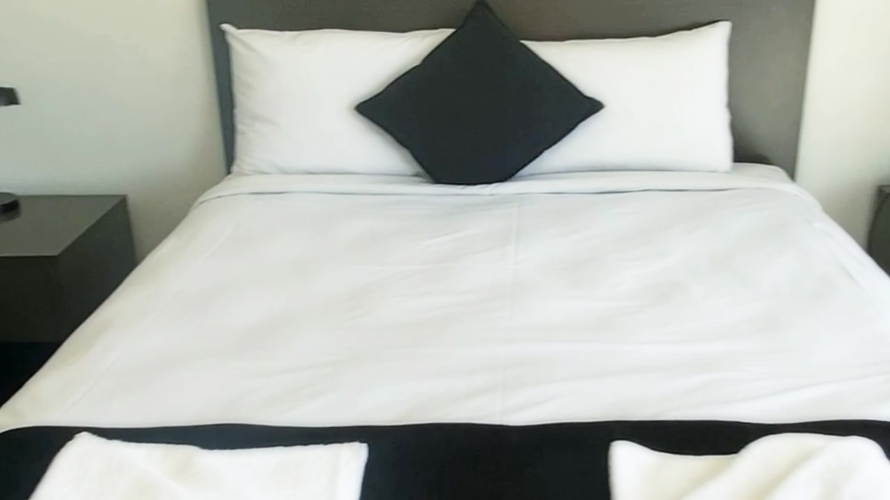 Deluxe Queen room at Dooleys Hotel Capella, crisp white linen and a black runner