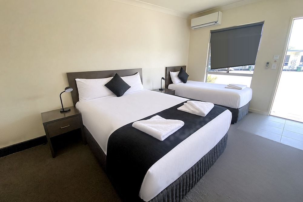 Deluxe Twin room with a queen bed and a king single by the window